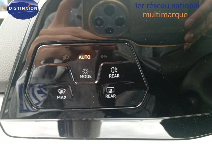 Gros plan sur les commandes d'éclairage et de dégivrage arrière d'une Volkswagen Golf VIII bleu Atlantique métal.