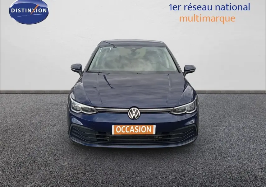 Vue frontale d'une Volkswagen Golf VIII bleu Atlantique métallisé avec plaque "OCCASION" sur un sol gris.
