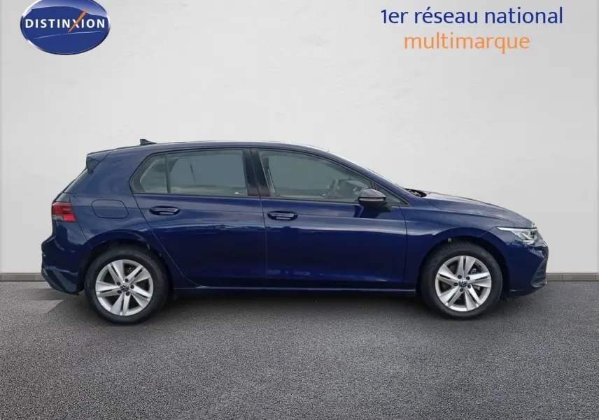 Profil côté gauche d'une Volkswagen Golf VIII bleu Atlantique métallisé avec jantes alliage et cinq portes visibles.