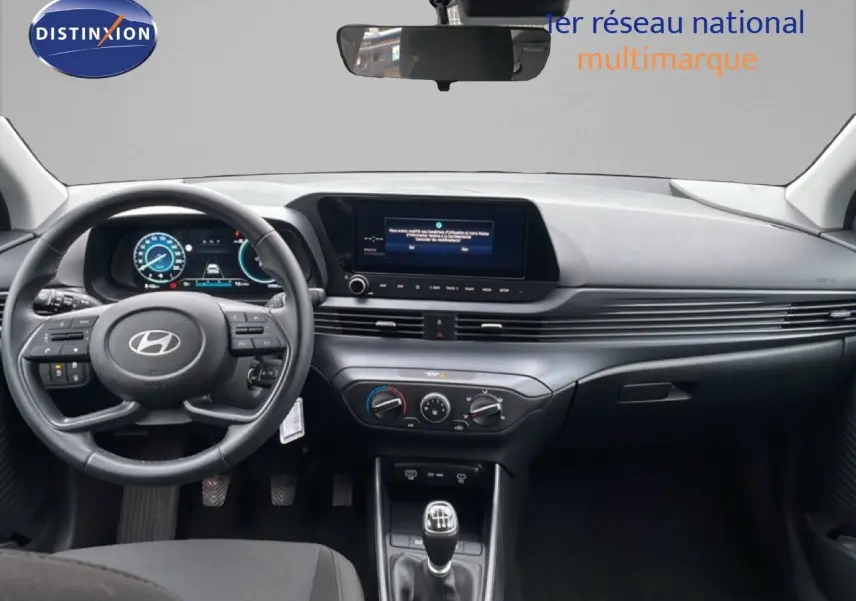 Intérieur de la Hyundai i20 2025, vue frontale du tableau de bord avec volant cuir et écran tactile central.