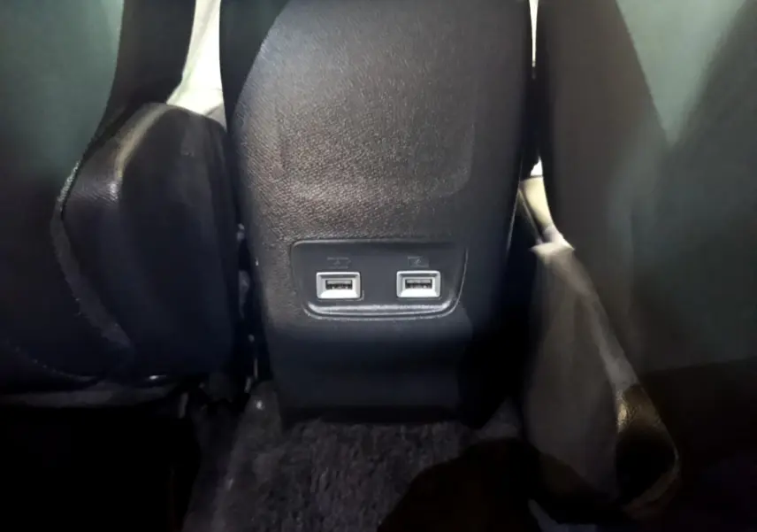 Prise double USB arrière noire entre les sièges du Peugeot 2008 BlueHDi 130 de 2021.