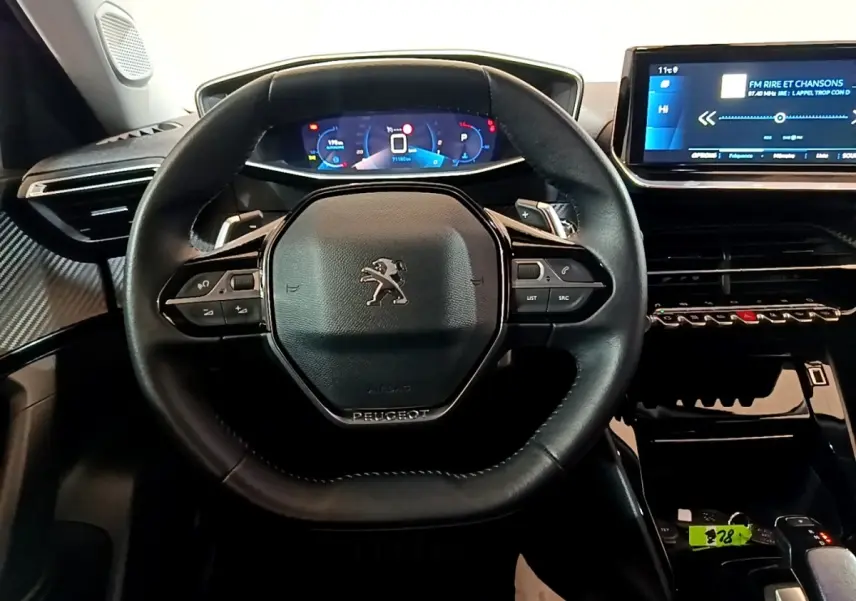 Vue rapprochée du volant cuir noir et du tableau de bord numérique bleu du Peugeot 2008 version 2021.
