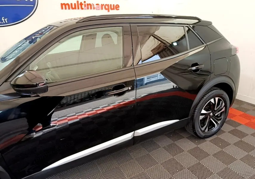 Profil côté gauche du Peugeot 2008 noir 2021, mettant en valeur les lignes sculptées et les jantes alliage noires.