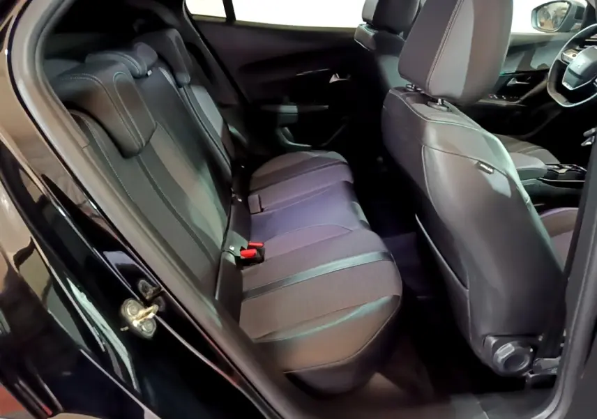 Vue intérieure côté gauche montrant la banquette arrière et les sièges avant noirs du Peugeot 2008 2021.