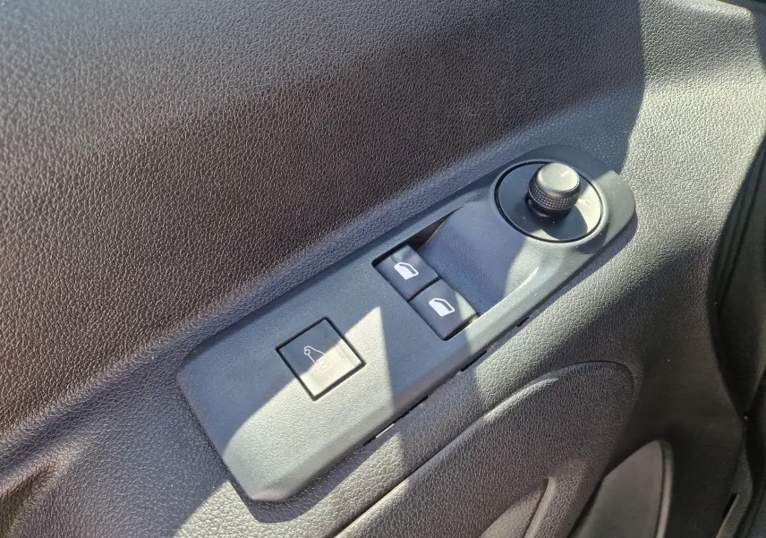 Gros plan sur les commandes de réglage des rétroviseurs et des vitres côté conducteur du Citroën Berlingo blanc 2020.