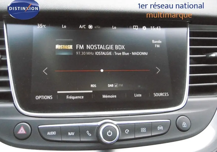 Écran tactile central du tableau de bord de l'Opel Grandland X gris Himalaya, affichant la radio FM Nostalgie.