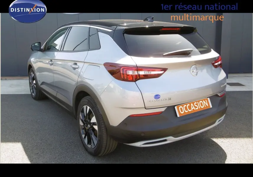 Opel Grandland X gris Himalaya vu en 3/4 arrière droit avec toit noir et feux arrière LED allumés