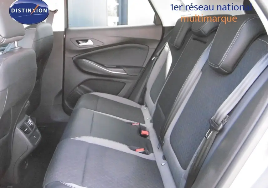 Vue latérale intérieure arrière montrant les sièges en cuir noir et tissu gris du Grandland X hybride rechargeable 2021