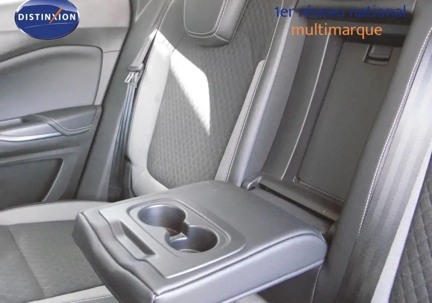 Vue rapprochée de l'accoudoir central arrière avec porte-gobelets dans l'habitacle gris et noir de l'Opel Grandland X.