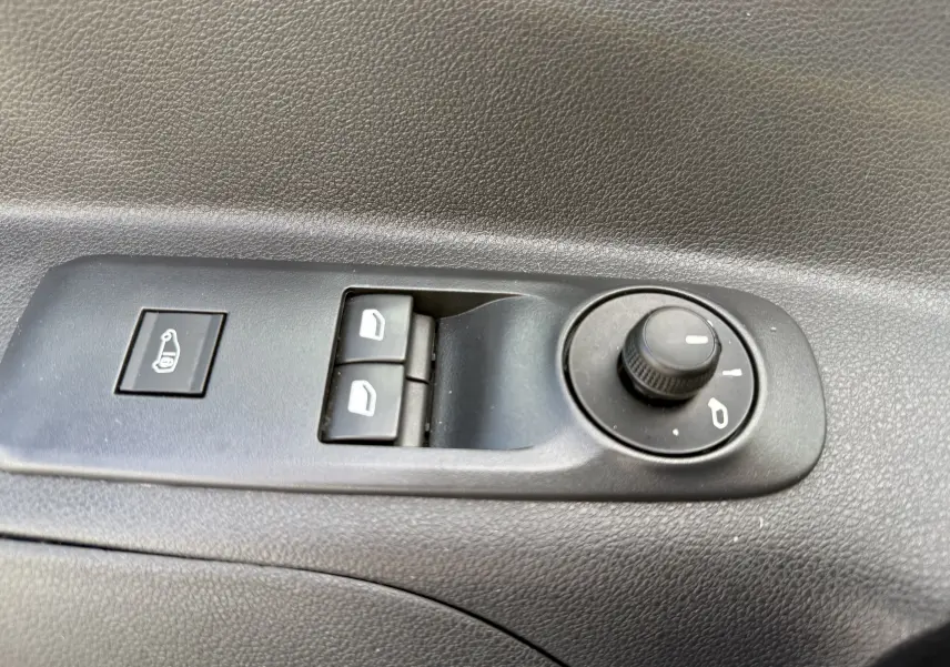 Commande de réglage des rétroviseurs et des vitres électriques sur la porte intérieure d'un Peugeot Partner blanc 2021.