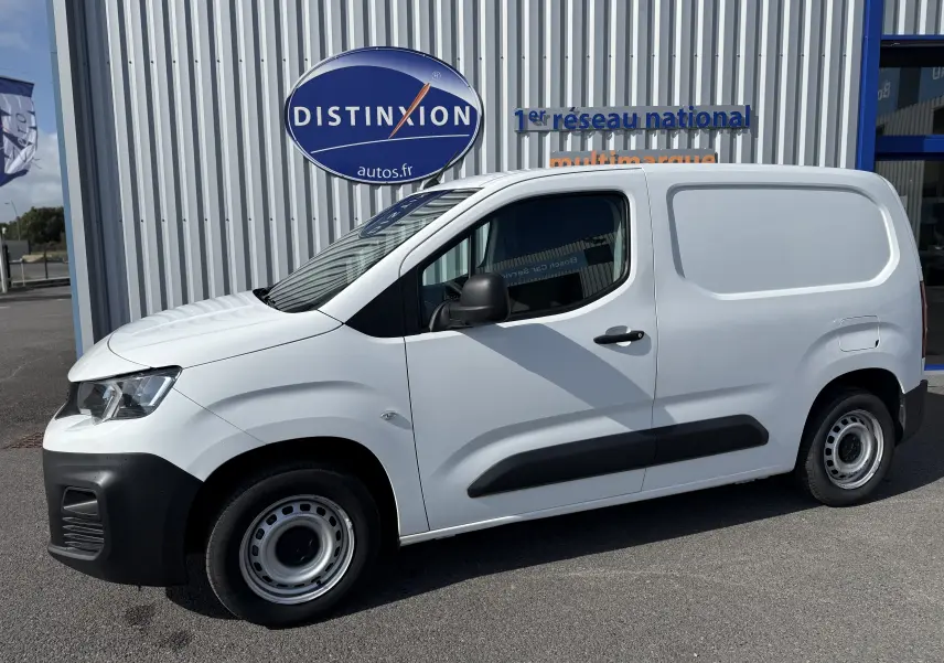 Vue de profil côté gauche d'un utilitaire Peugeot Partner blanc avec porte latérale et jantes acier simples.