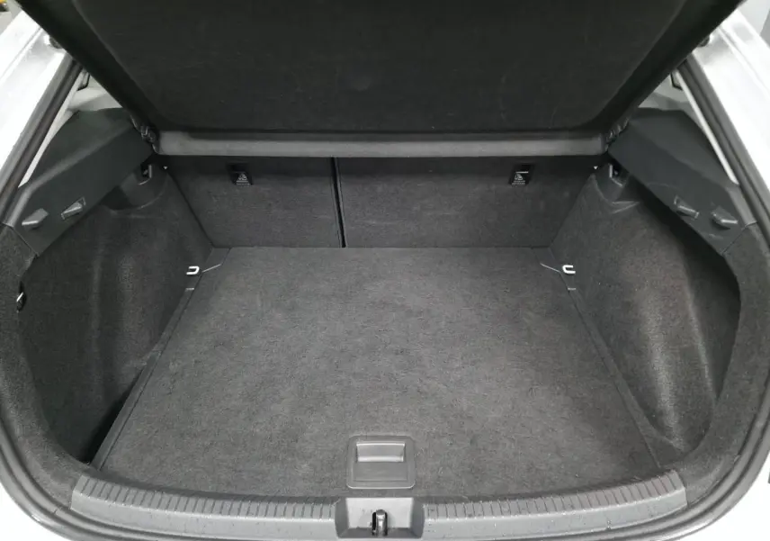 Coffre ouvert du Volkswagen Taigo blanc, vue arrière montrant un espace de chargement propre et spacieux.