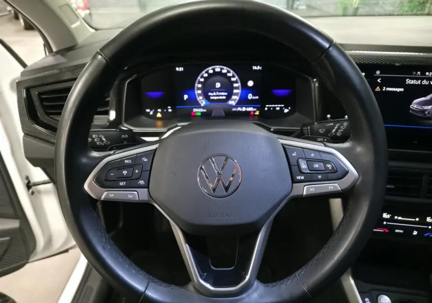 Vue rapprochée du volant multifonctions en cuir d'une Volkswagen Taigo 2024 avec tableau de bord numérique allumé.