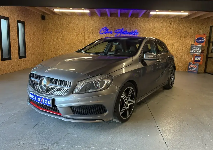 Mercedes Classe A 250 AMG Sport gris vue 3/4 avant droit en intérieur, avec jantes noires et détails rouges sur le pare-chocs.