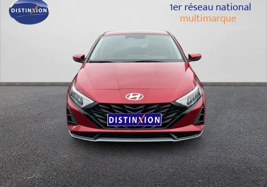Vue frontale d'une Hyundai i20 2025 rouge dragon métal avec calandre noire et phares LED distinctifs.