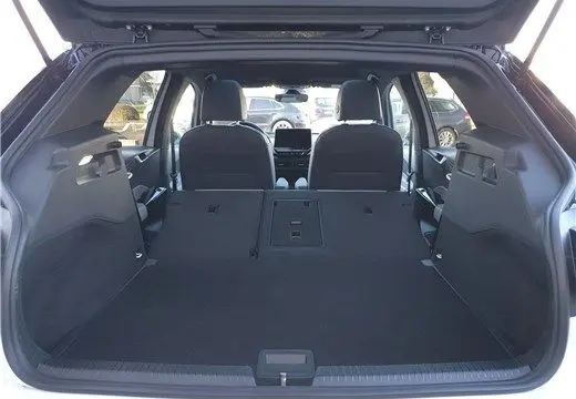 Vue depuis le coffre ouvert d'un Volkswagen ID.3 blanc glacier, montrant l'espace intérieur avec sièges arrière rabattus.