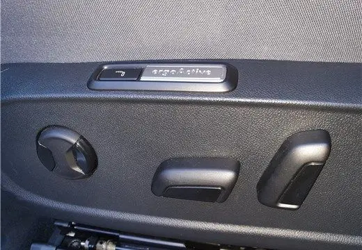 Gros plan sur les commandes de réglage électrique du siège conducteur d'une Volkswagen ID.3 blanc glacier.