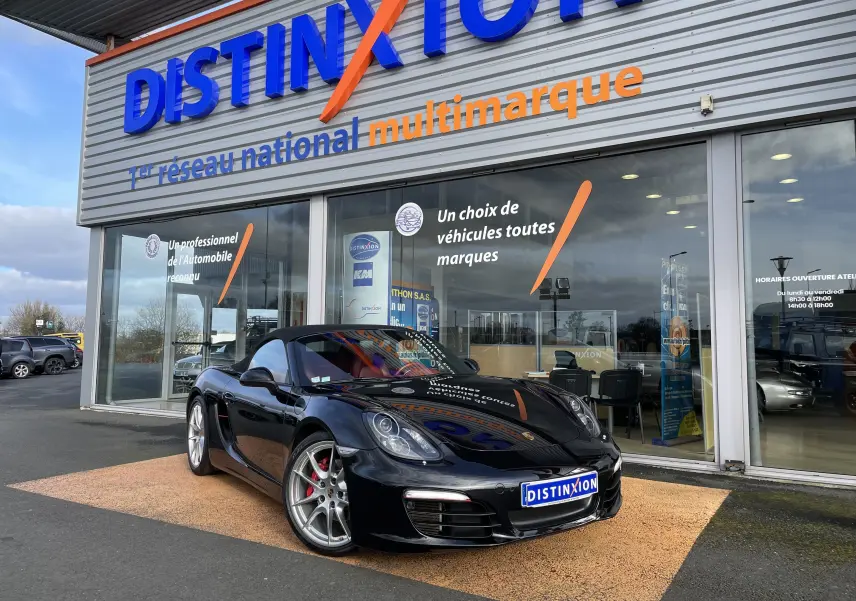 Porsche Boxster S noir intense vue 3/4 avant droit, capote noire, jantes Carrera S 20 pouces, devant showroom Distinxion.