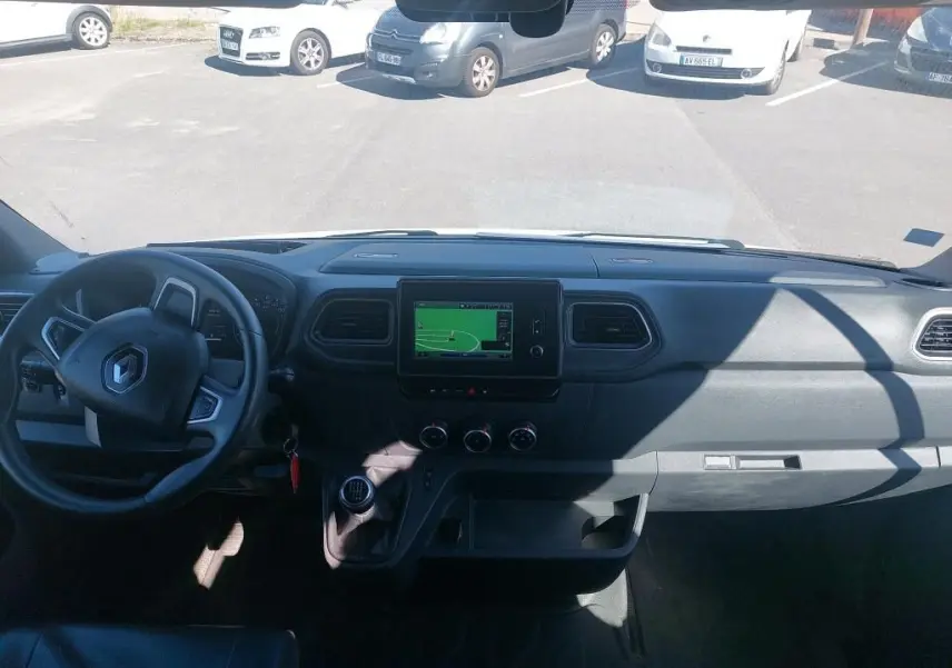 Vue intérieure avant du tableau de bord du Renault Master Blanc 2021 avec écran tactile et volant à gauche.