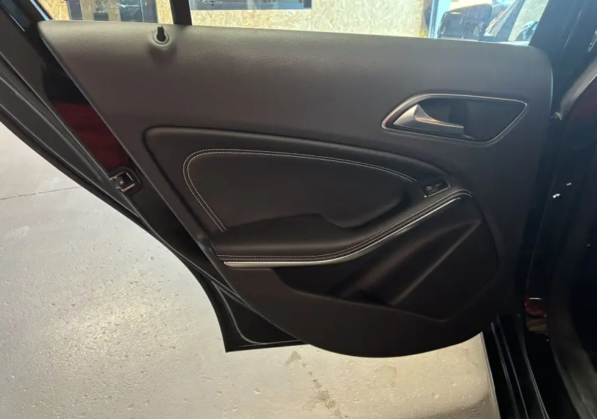 Porte arrière gauche noire de Mercedes Classe A 180 CDI 2018, intérieur cuir noir avec surpiqûres blanches et commande de vitre électrique.