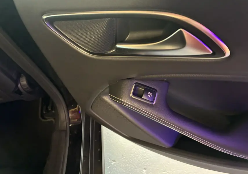 Poignée intérieure côté gauche de porte noire avec bouton de commande de vitre sur Mercedes Classe A 180 CDI Sensation 2018.