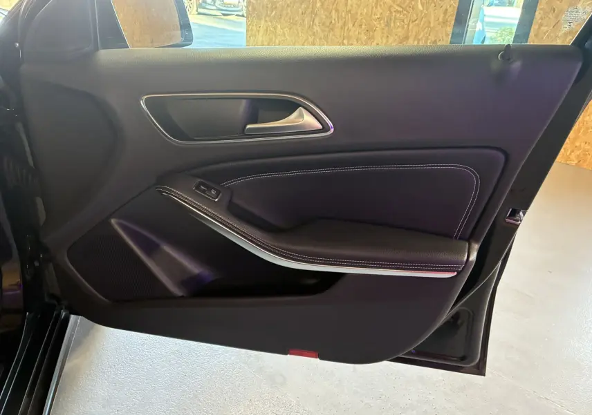 Porte avant gauche noire de Mercedes Classe A 180 CDI 2018, avec garniture cuir noir et surpiqûres blanches.