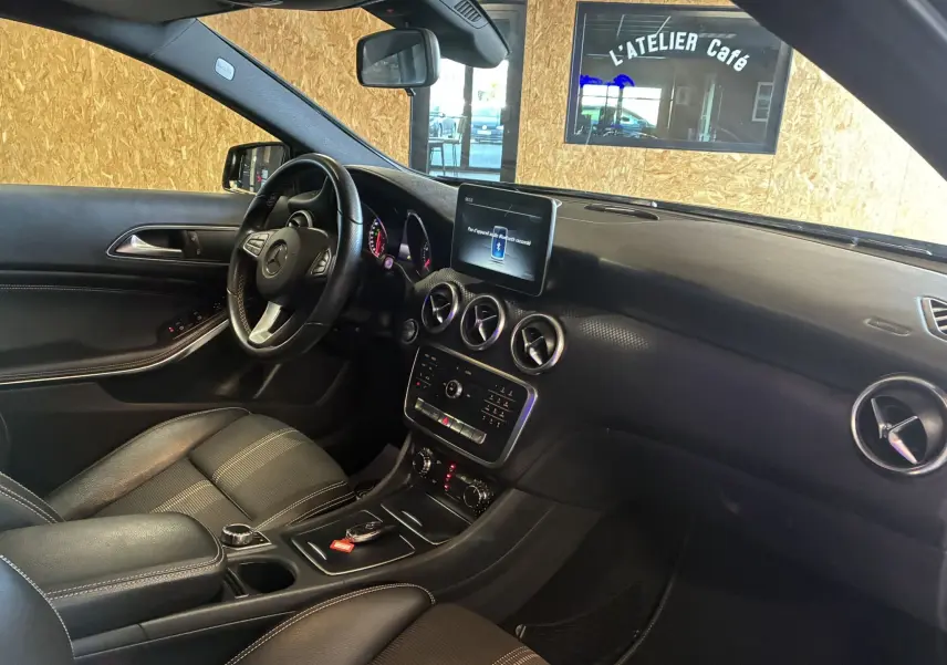 Intérieur noir de la Mercedes Classe A 180 CDI Sensation 2018, vue côté gauche sur tableau de bord et volant cuir.