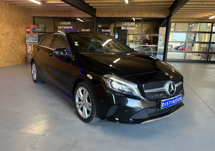 Mercedes Classe A 180 CDI noir vue 3/4 avant droit dans un atelier avec plaques Distinxion visibles.