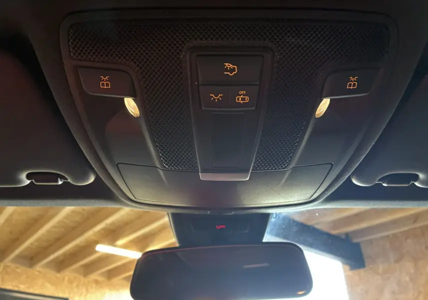 Vue intérieure du plafonnier noir avec commandes d'éclairage et rétroviseur dans une Mercedes Classe A 180 CDI Sensation 2018.