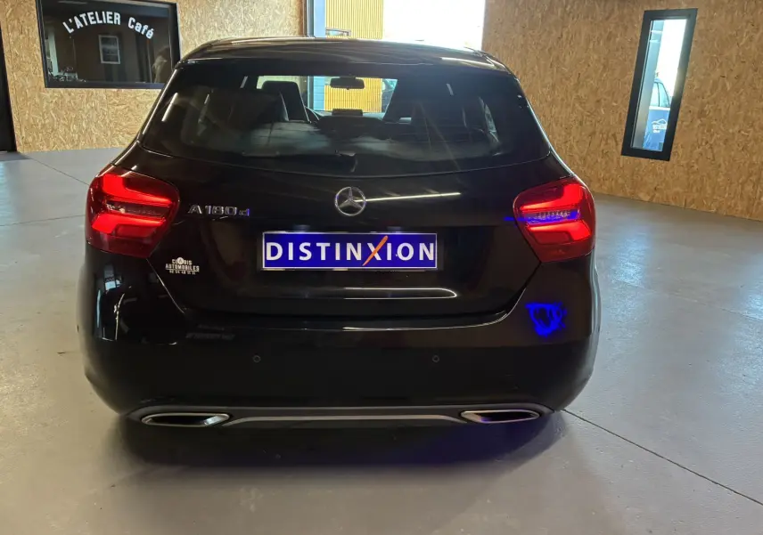 Vue arrière d'une Mercedes Classe A 180 CDI noire de 2018 avec feux arrière allumés dans un garage.