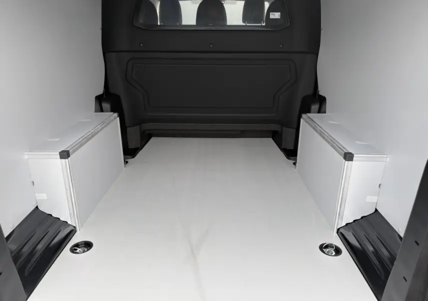 Vue arrière de l’espace de chargement du Citroën Jumpy XL gris titane avec plancher bois et coffrages latéraux.