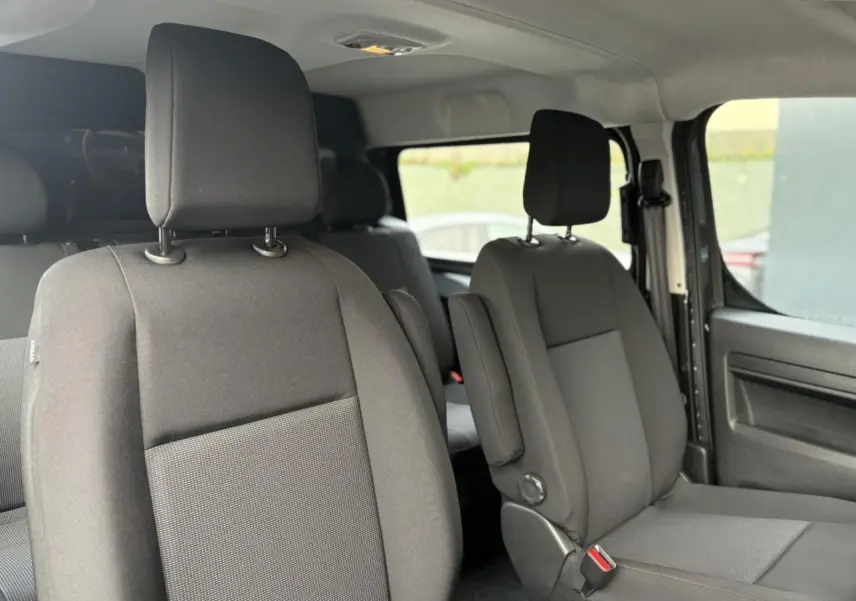 Vue intérieure côté droit des sièges avant en tissu bi-ton noir et gris du Citroën Jumpy XL 2025.