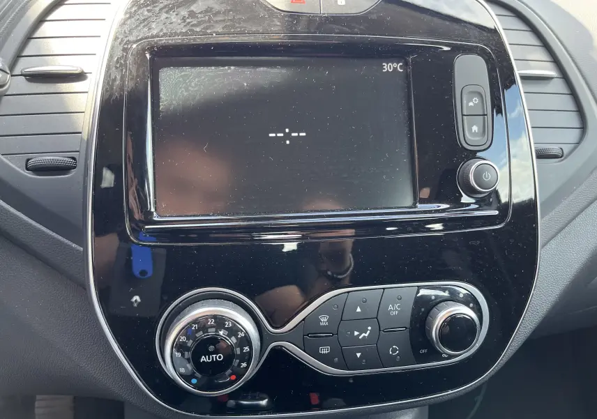 Tableau de bord noir du Renault Captur 2019 avec écran tactile et commandes climatisation en gros plan.