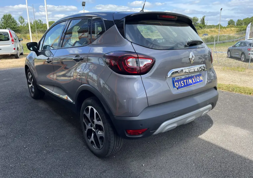 Renault Captur gris en vue 3/4 arrière droit, avec feux arrière LED et jantes alliage noires.