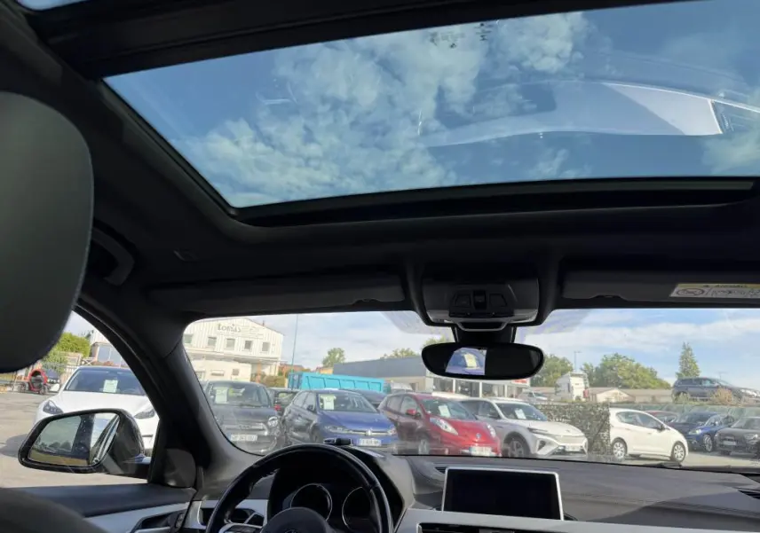 Vue intérieure du toit ouvrant panoramique en verre du BMW X2 sDrive 18d M Sport 2021 avec ciel bleu visible.