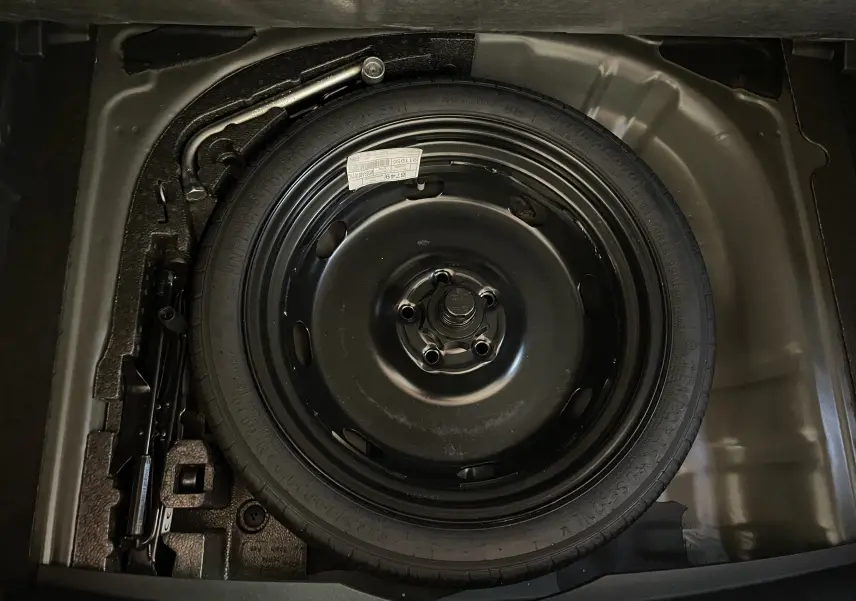 Gros plan sur la roue de secours compacte noire du coffre du CUPRA Formentor 2025 en peinture Noir Minuit.