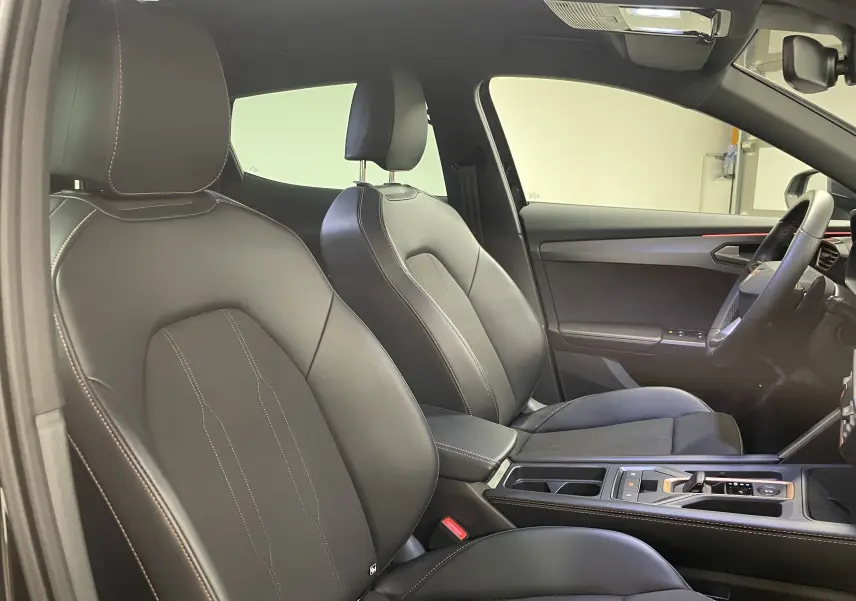 Vue intérieure côté conducteur du CUPRA Formentor 2025 noir minuit, montrant les sièges en cuir et la console centrale moderne.