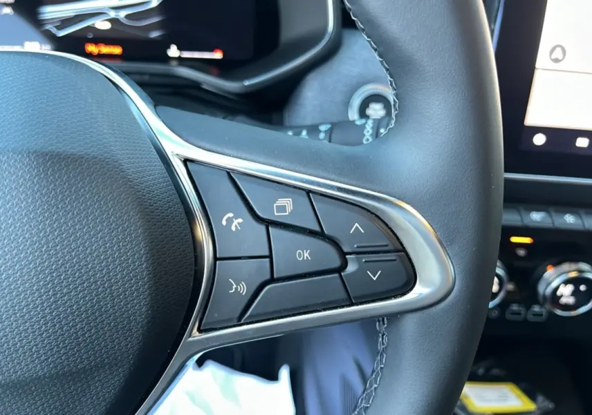 Gros plan sur le volant cuir multifonctions de la Renault Clio V TCE 90 Techno Plus avec commandes intégrées.