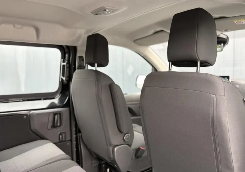 Vue intérieure côté gauche du Citroën Jumpy XL 2025 noir Perla, montrant les sièges avant et banquette arrière tissu bi-ton.