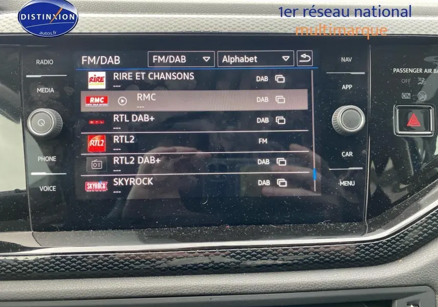 Écran tactile central de la Volkswagen Polo 2025 affichant les stations radio FM/DAB avec cadre noir et décor lava stone.