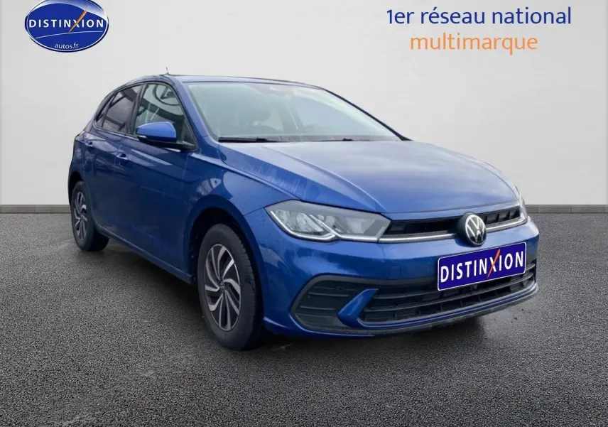 Volkswagen Polo 1.0 TSI bleu récif en vue 3/4 avant droit sur sol gris, avec calandre et phares LED visibles.