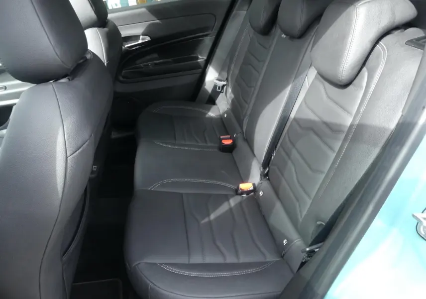 Vue latérale des sièges arrière en cuir noir du Jeep Avenger 2024, avec portières et ceintures visibles.