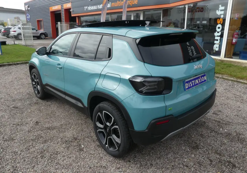 Vue 3/4 arrière droite d'un Jeep Avenger bleu métallisé avec vitres surteintées et jantes alliage 18 pouces.