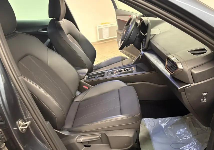 Vue intérieure côté conducteur du CUPRA Formentor gris magnétique, avec sièges en cuir noir et tableau de bord moderne.