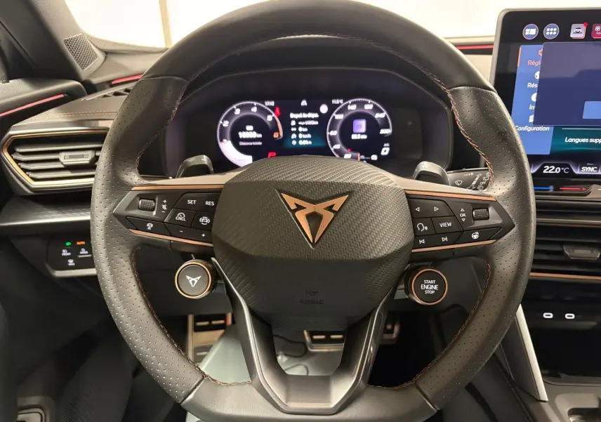 Vue rapprochée du volant perforé noir avec logo CUPRA cuivré et tableau de bord numérique du Formentor 2025.