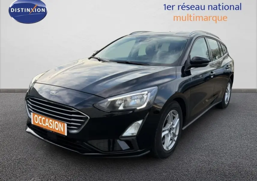 Ford Focus SW noire vue en 3/4 avant droit avec barres de toit et jantes alliage 16 pouces.
