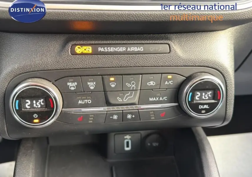 Gros plan sur la console de climatisation automatique de la Ford Focus SW noire, affichant 21,5°C en mode dual.