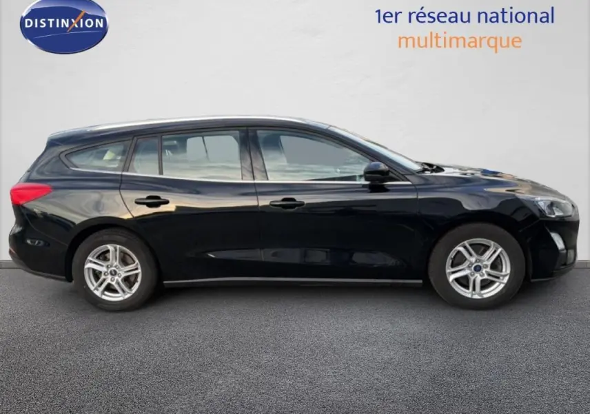 Profil côté gauche d'une Ford Focus SW noire 2019 avec jantes alliage 16 pouces et barres de toit visibles.