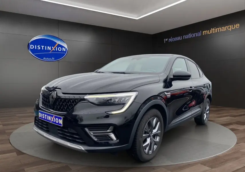 Renault Arkana noir vue 3/4 avant droit en intérieur, avec calandre distinctive et feux LED allumés.
