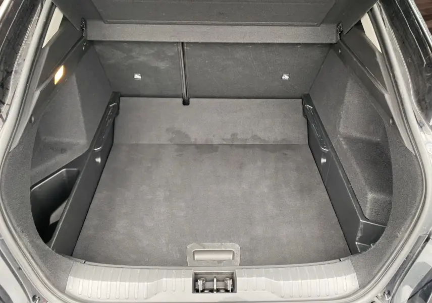 Coffre ouvert du Renault Arkana noir 2024, vue de dessus montrant un espace de rangement propre et spacieux.